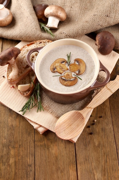 Sopa de champiñones en una olla sobre fondo de madera