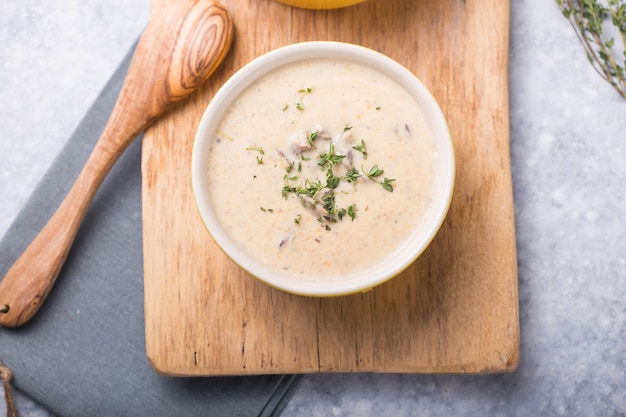 Foto sopa de champiñones sobre tabla de madera