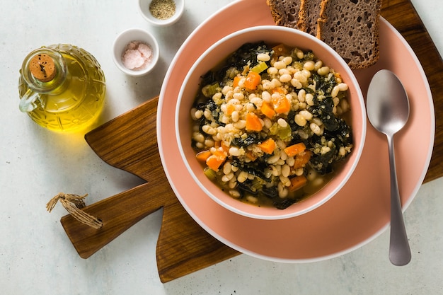 Sopa con col rizada y frijoles en un bol