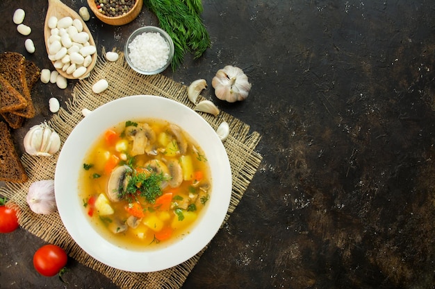 Foto sopa com cogumelos e ervas em fundo escuro prato vegetariano prato quente copiar espaço