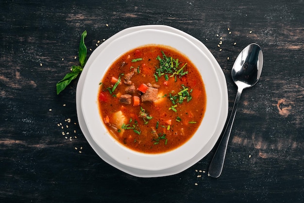 Sopa com tomate bovino e legumes frescos Em um fundo de madeira Vista superior Copiar espaço