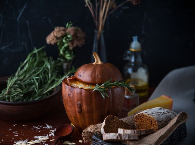 Sopa de crema de calabaza estilo rústico sobre fondo oscuro