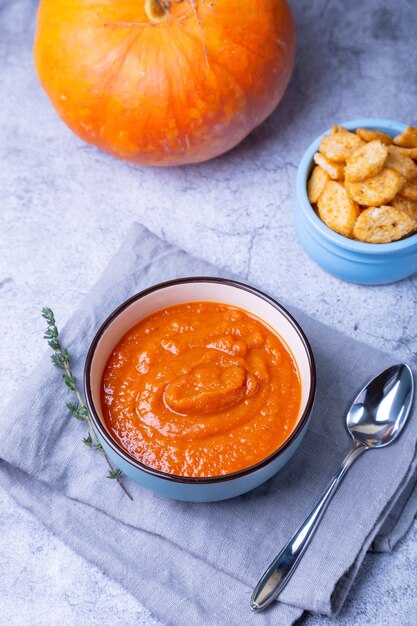 Sopa de crema de calabaza con picatostes y tomillo en un bol