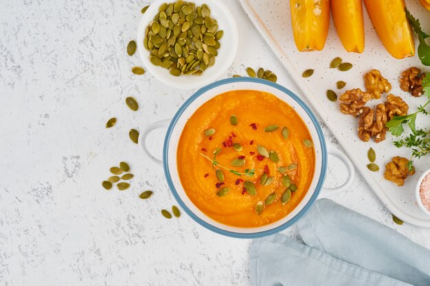 Sopa crema de calabaza con semillas, espacio de copia de fondo blanco claro vista superior