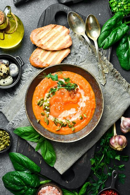 Sopa de crema de calabaza y zanahoria con semillas de calabaza y crema en un tazón Concepto de comida saludable Cerrar