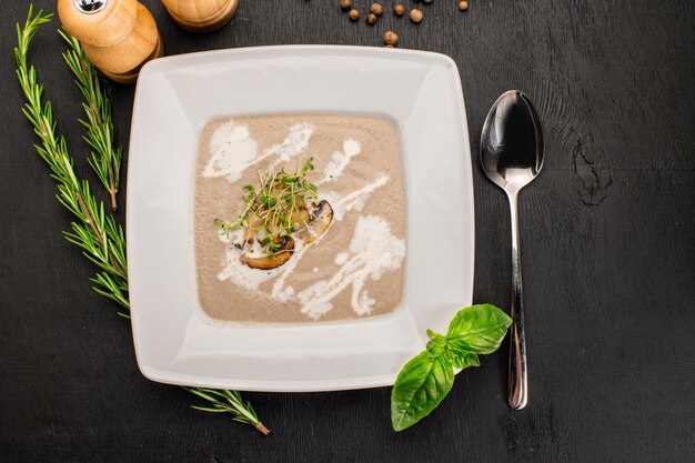 Sopa crema de champiñones con hierbas sobre fondo de madera