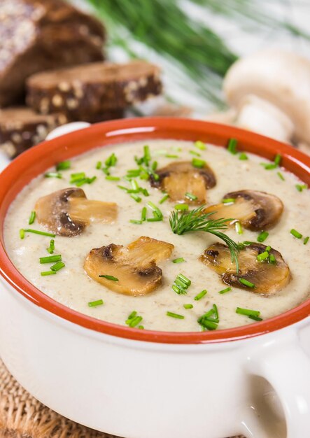 Foto sopa de crema con champiñones sobre un fondo de madera