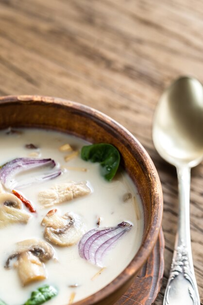 Sopa de crema de coco tailandesa sobre fondo de madera