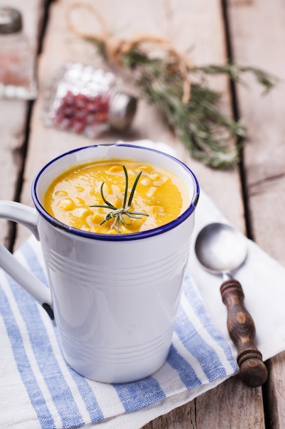 Sopa de crema de maíz con pasta de curry y romero, en una taza.