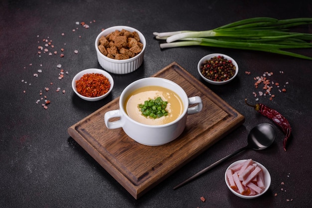 Sopa de crema con patatas, puerro y guisantes sobre una mesa de hormigón oscuro