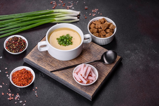 Sopa de crema con patatas, puerro y guisantes sobre una mesa de hormigón oscuro