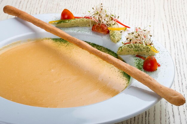 Sopa de crema con salmón sobre fondo blanco.