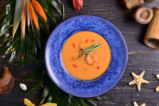 Foto sopa crema de tomate con camarones. en el plato azul