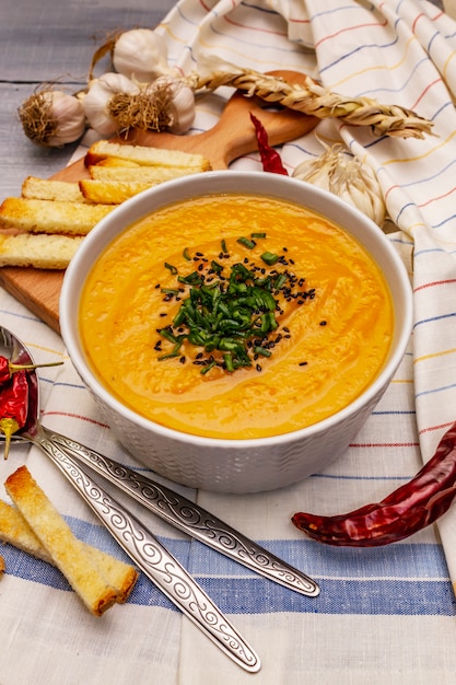 Sopa de crema de verduras. Concepto de nutrición saludable vegana (vegetariana). Ajos, picatostes, especias, condimentos aromáticos.