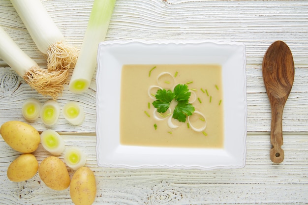 Foto sopa crema de vichyssoise con puerros en madera blanca