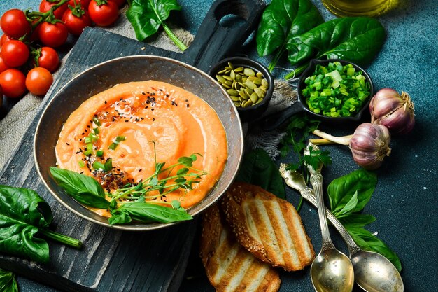 Sopa de crema de zanahoria vegana con albahaca y crema en un tazón El concepto de la comida vegetariana