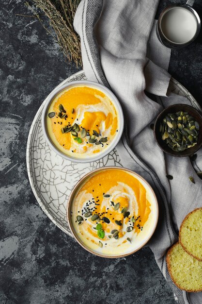 Sopa creme de abóbora com lentilhas e sementes de abóbora em um fundo escuro