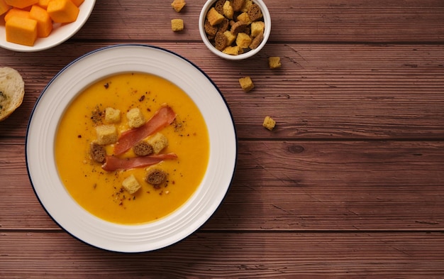 Sopa creme de abóbora em uma mesa de madeira