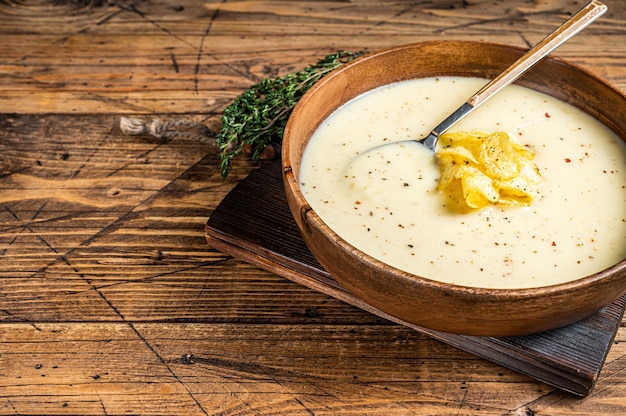 Sopa creme de batata com batata frita em prato de madeira