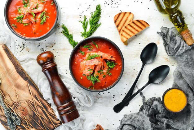 Sopa creme de tomate com camarões em uma tigela preta Menu de frutos do mar Vista superior Estilo rústico