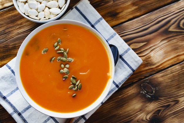 Sopa cremosa de calabaza en una mesa de madera marrón