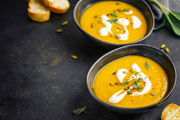 Sopa cremosa de calabaza servida en cuencos.