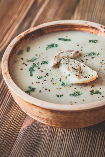 Sopa cremosa de champiñones en un cuenco de madera