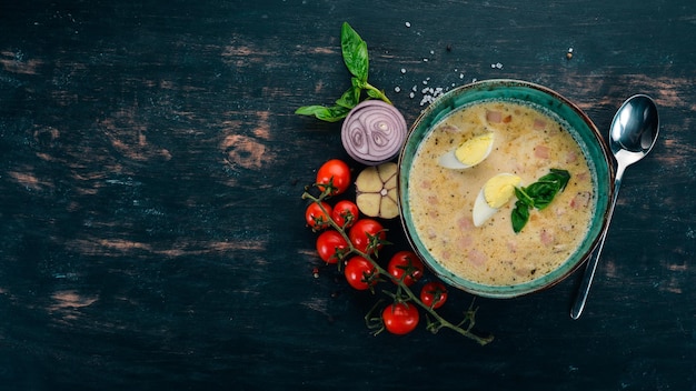 Sopa cremosa com bacon frango ovo legumes e manjericão Em uma mesa de madeira Vista superior Copiar espaço