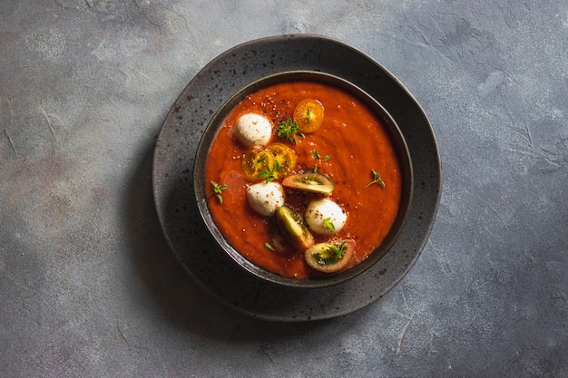 Sopa cremosa com vegetais assados decorada com mussarela e manjericão