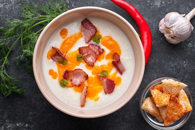 Sopa cremosa, couve-flor com bacon e croutons. endro, tomate cereja, alho e pimenta vermelha