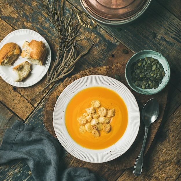 Sopa cremosa de abóbora com croutons e sementes a bordo