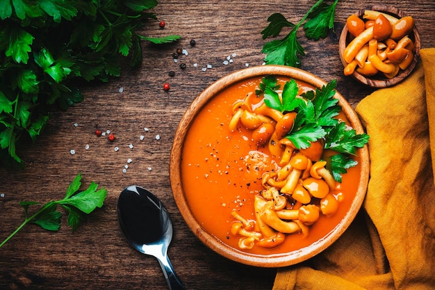 Sopa cremosa de abóbora picante com pimenta de cogumelos e salsa Inverno ou outono comida vegetariana vegana saudável Tigela de sopa no fundo da mesa de madeira rústica Vista superior