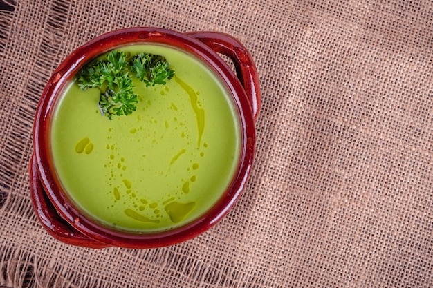 Foto sopa cremosa de aspargos frescos e ingredientes na mesa de madeira, foco seletivo