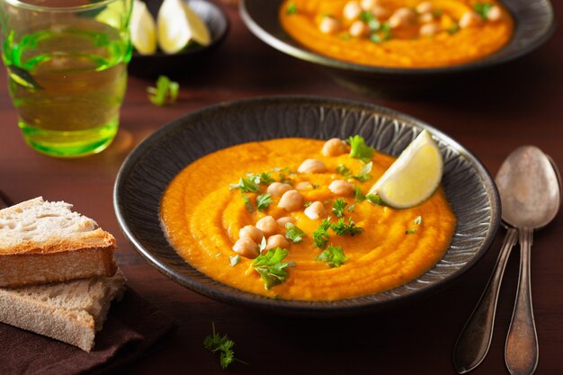 Sopa cremosa de grão de bico de cenoura no fundo rústico escuro