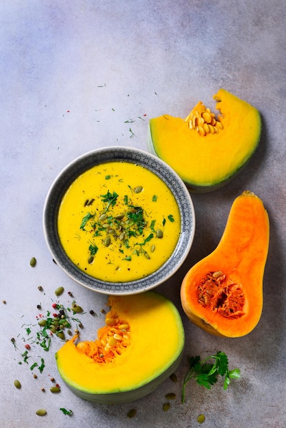 Sopa cremosa de legumes e lentilhas cortada sementes de abóbora salsa em fundo cinza claro Espaço de cópia de vista superior