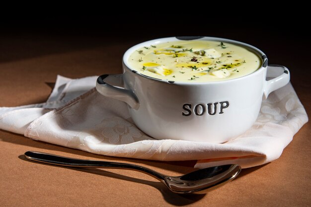 Sopa cremosa de queijo em tigela esmaltada em fundo rústico