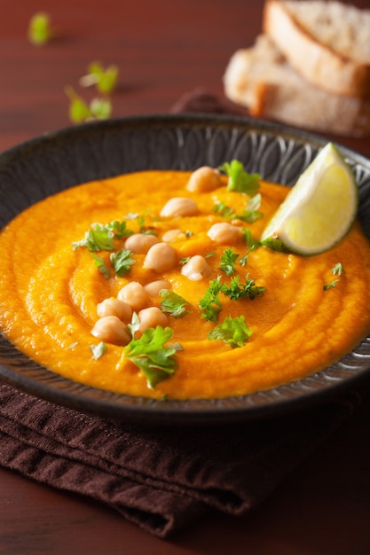 Sopa cremosa de garbanzos y zanahorias en rústica oscura