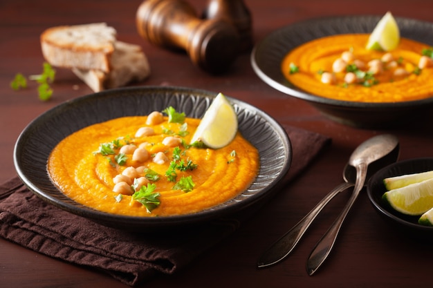 Sopa cremosa de garbanzos y zanahorias sobre fondo rústico oscuro