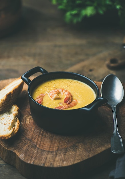 Sopa cremosa de maíz con gambas servida en espacio de copia de olla