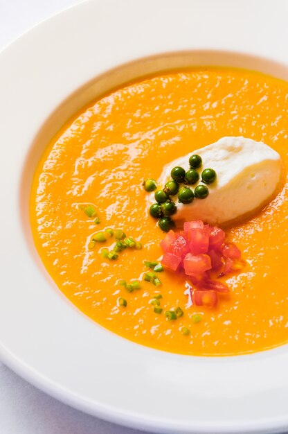 Sopa cremosa de maíz de tomate y pimiento verde en la mesa blanca, sopa francesa de Veloute