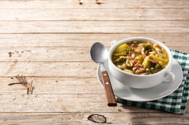 Sopa cremosa toscana en un tazón sobre mesa de madera