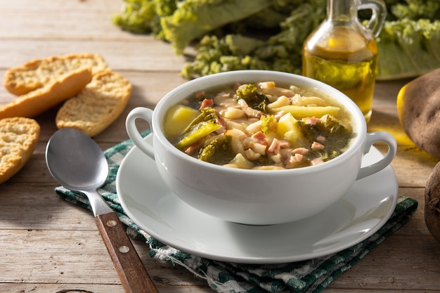 Foto sopa cremosa toscana en un tazón sobre mesa de madera