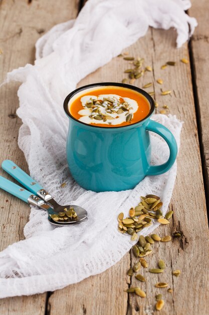 Sopa de abóbora com sementes de abóbora em um copo