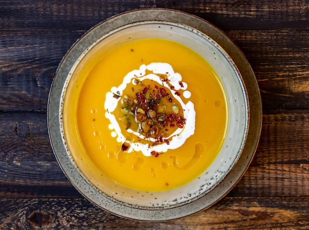 Sopa de abóbora em um de madeira. Alimentação saudável.