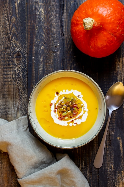 Sopa de abóbora em um de madeira. Alimentação saudável.