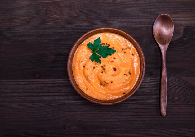 Sopa de abóbora em um prato de barro redondo