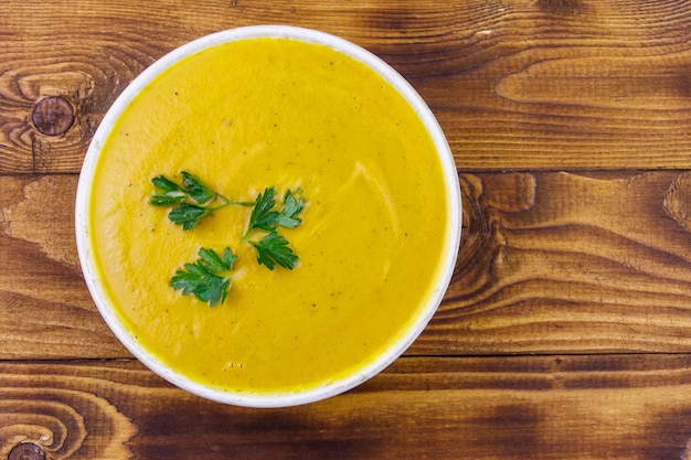 Sopa de abóbora em uma mesa de madeira Vista superior