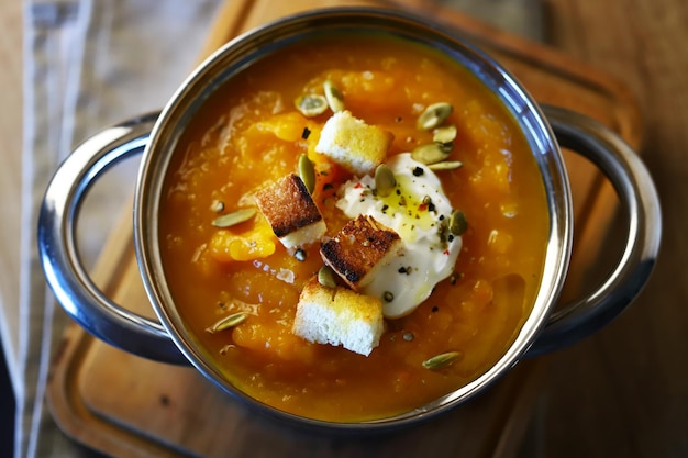 Sopa de abóbora em uma panela com croutons