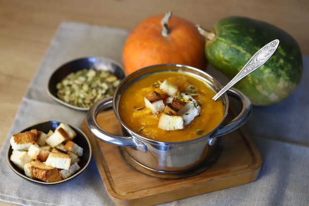 Sopa de abóbora em uma panela com croutons