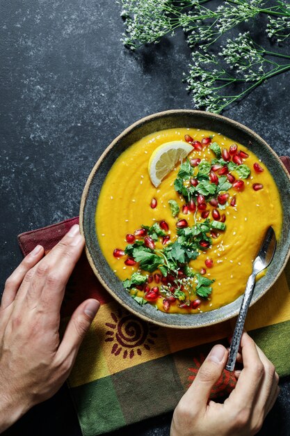 Sopa de abóbora fresca coberta com sementes de salsa e romã